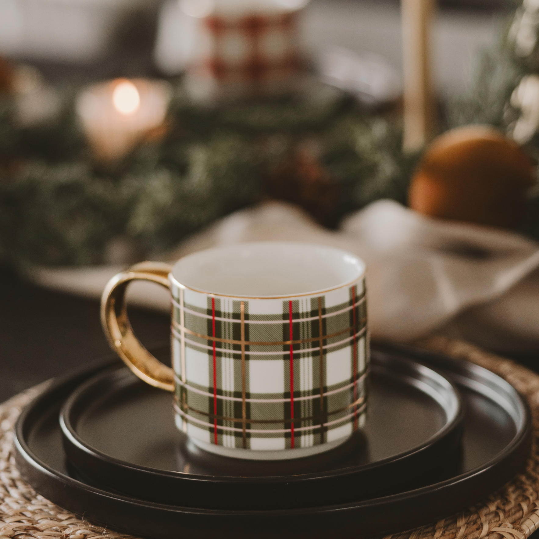 Plaid mug on a black tray with a blurred festive background
