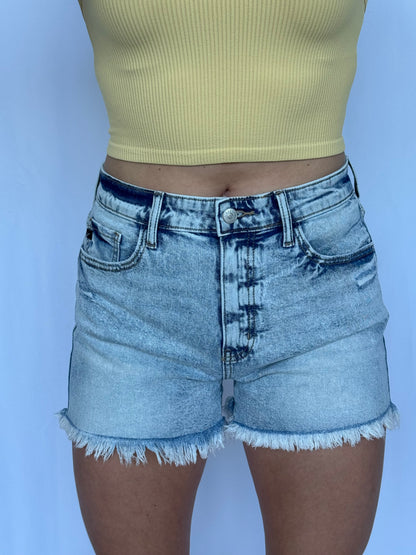 Person wearing light blue denim shorts on a white background