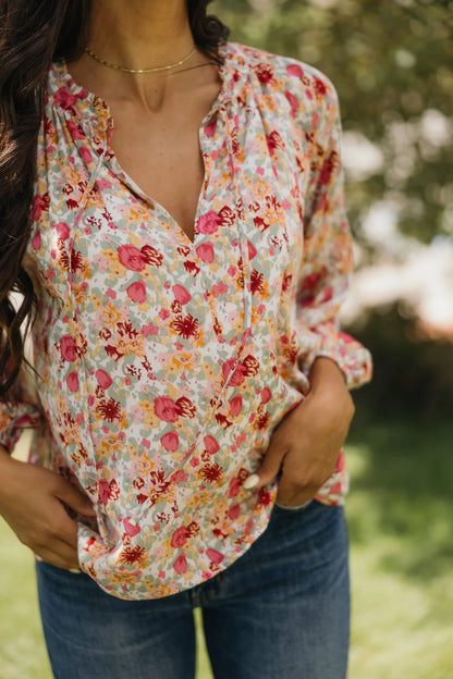 Woman wearing a floral blouse with a blurred green background