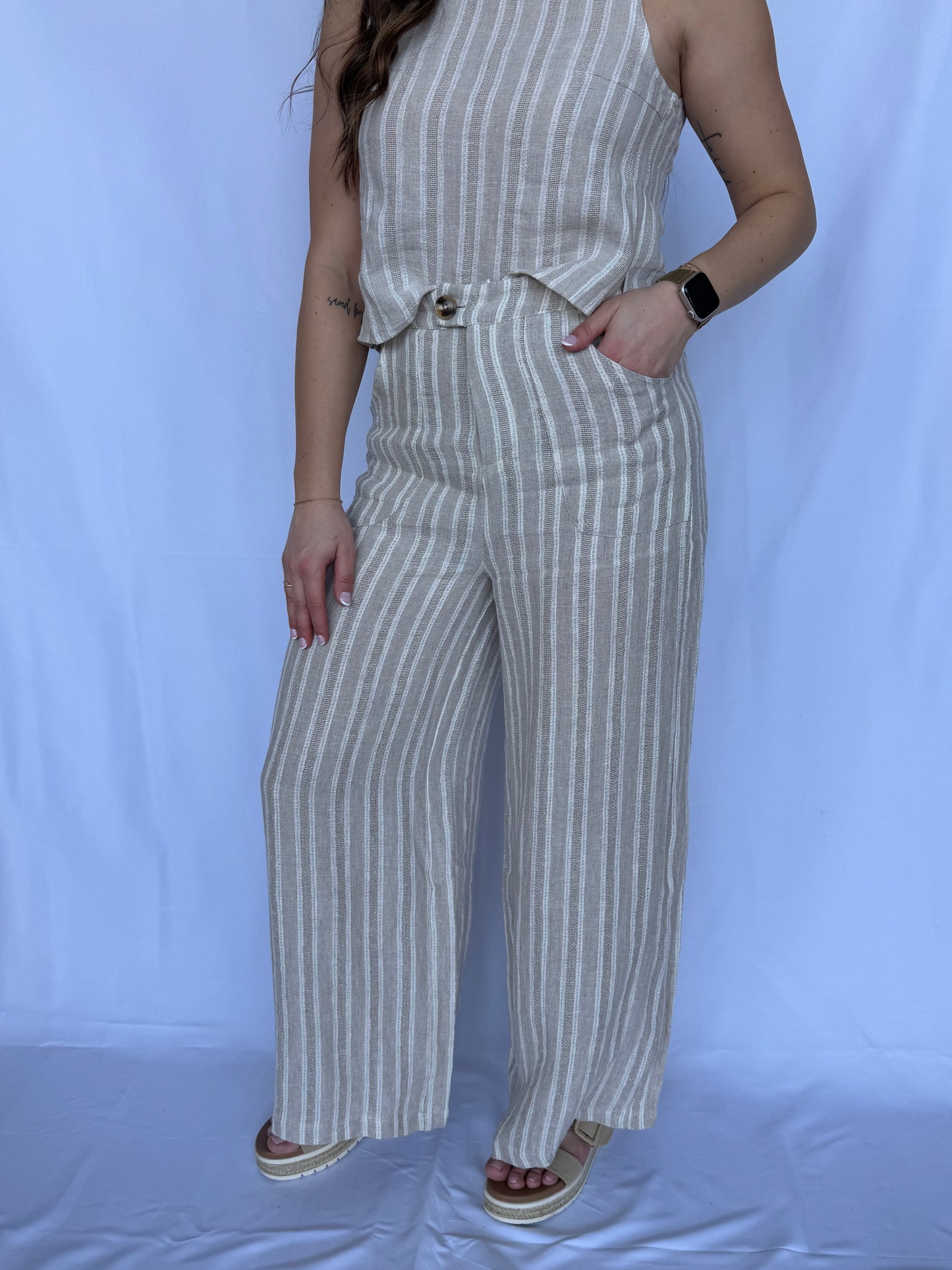 Person wearing a striped outfit with wide-leg pants on a white background