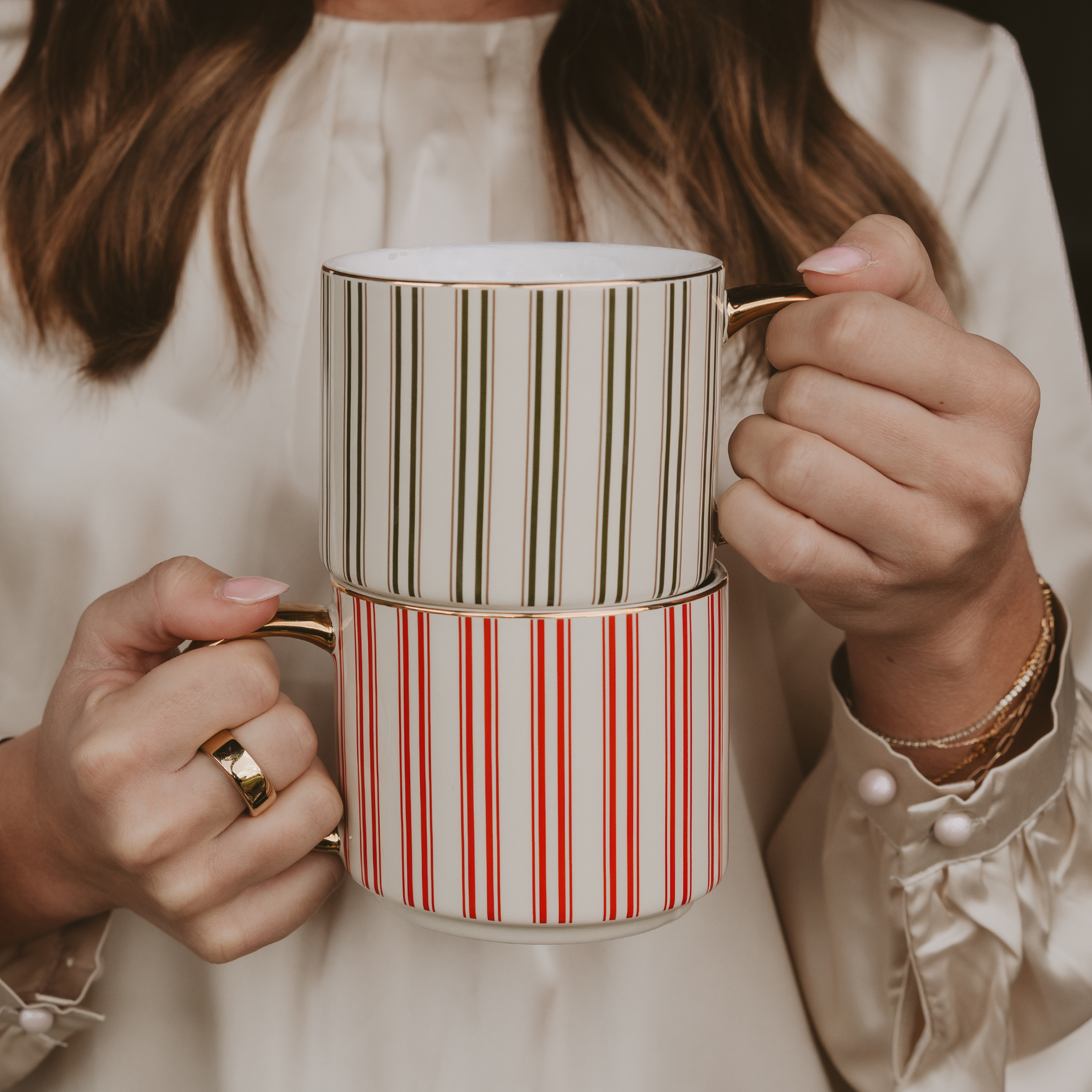 Person holding a mug with red and white striped design