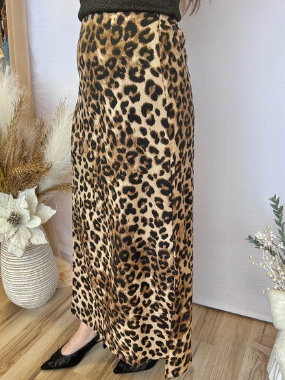 Person wearing a leopard print skirt with a plain background