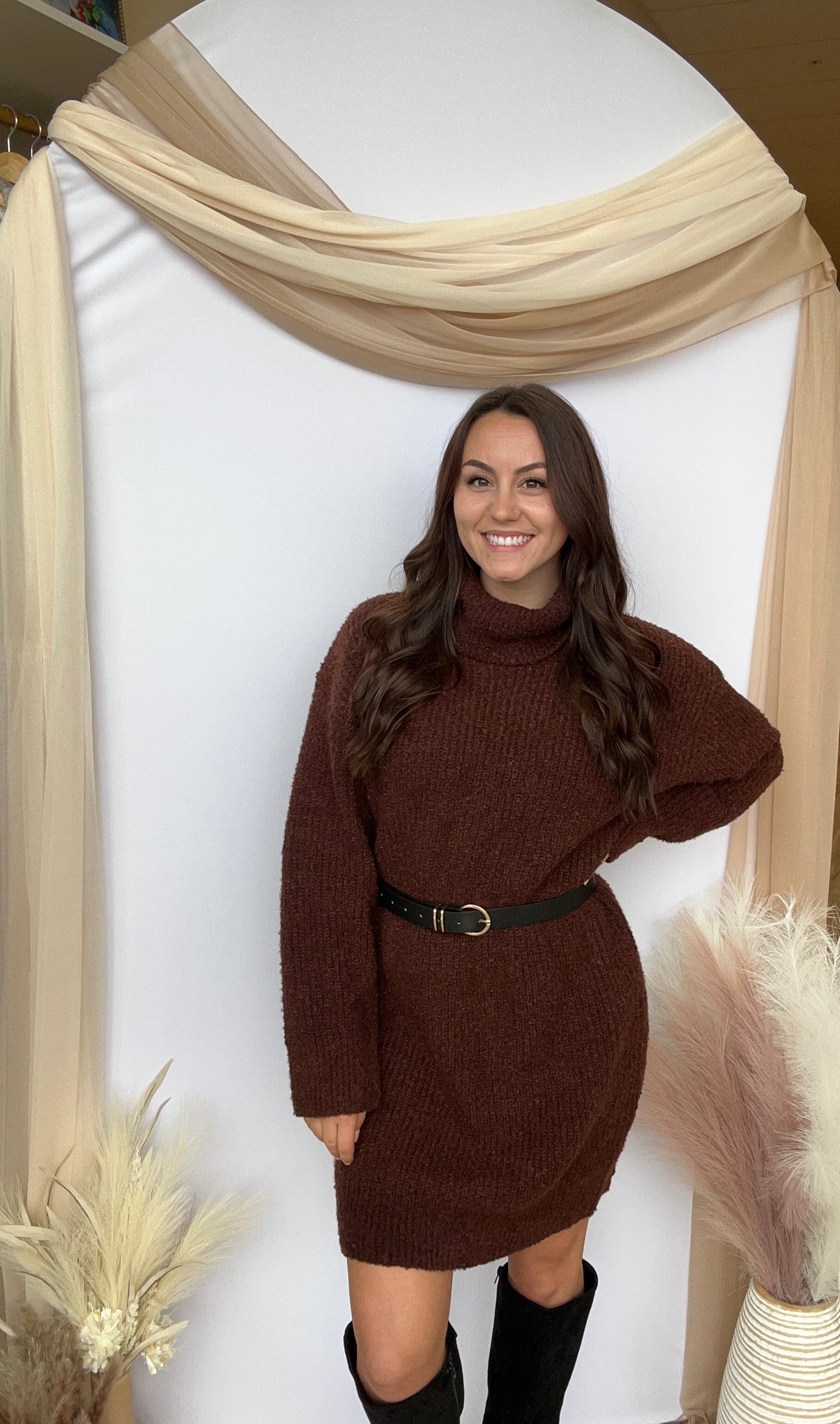Woman lying on a white mattress in a store setting with decorative elements.