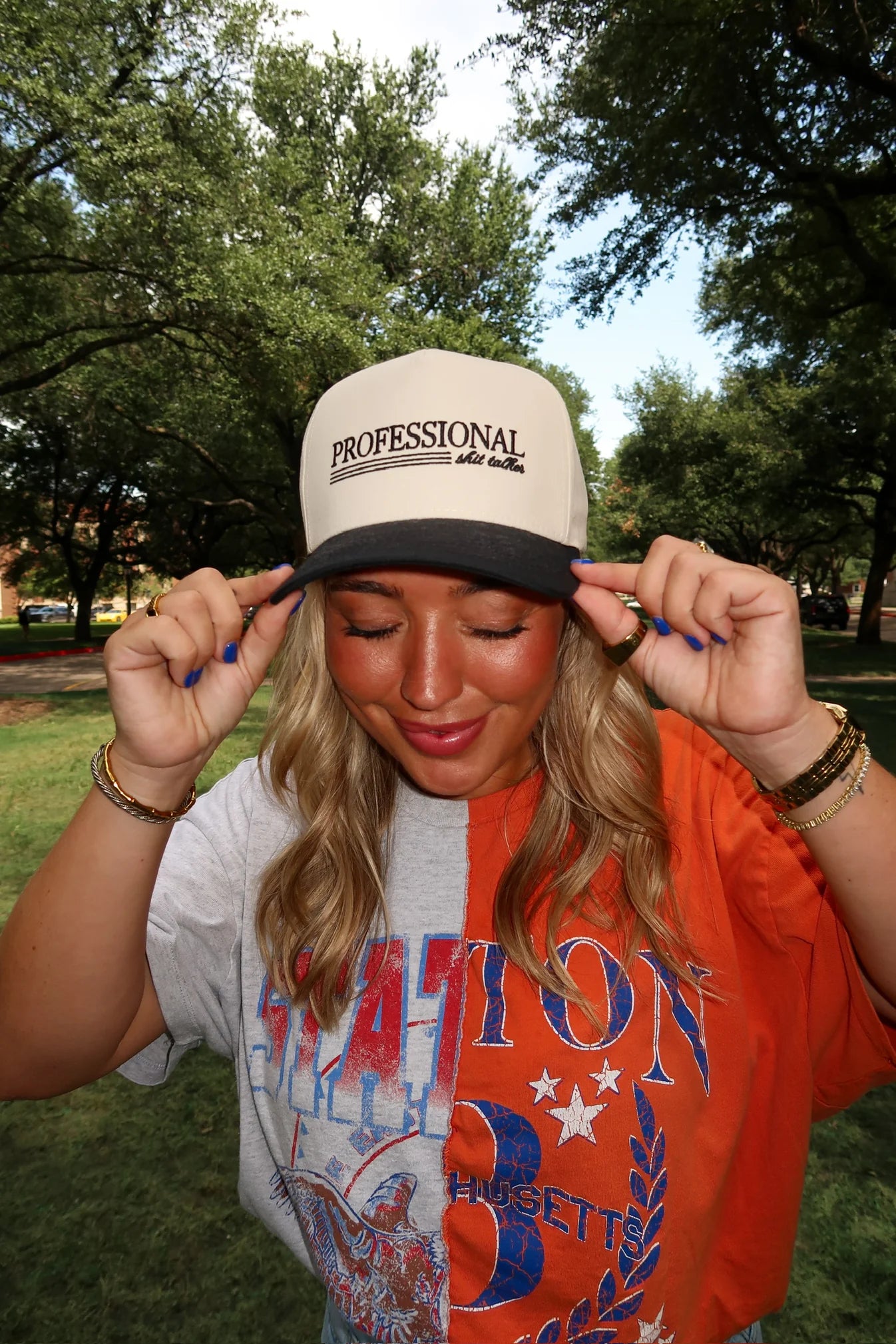 Person wearing a cap and colorful shirt outdoors with trees in the background